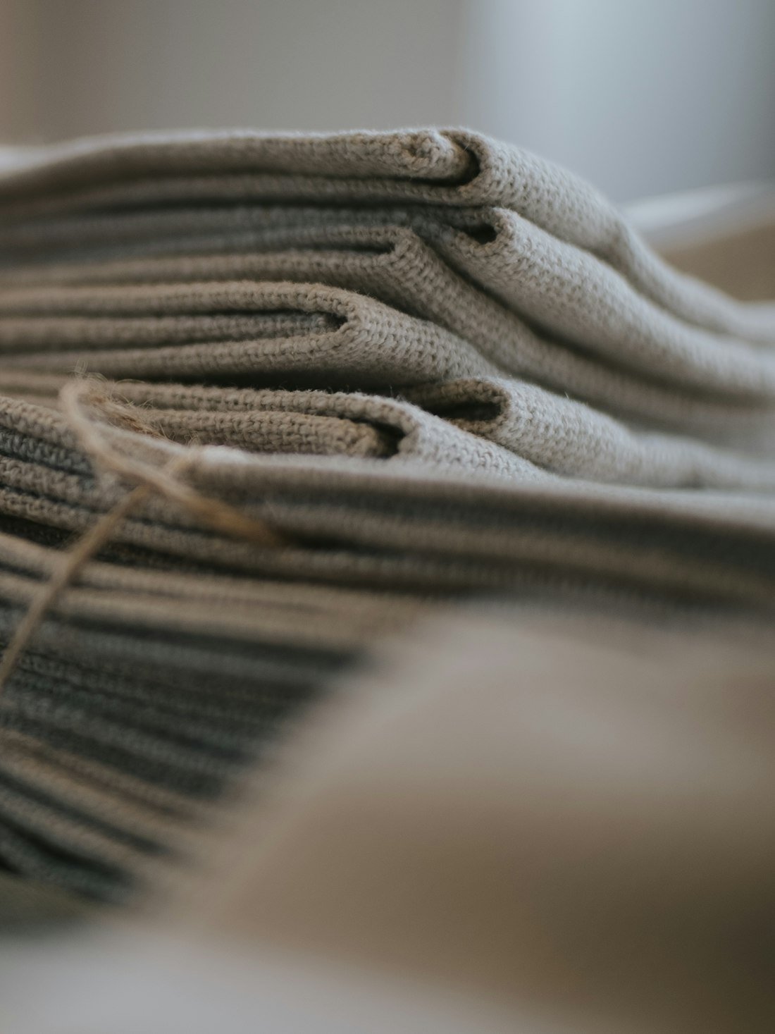 Stack of folded knitted fabric in soft neutral tones