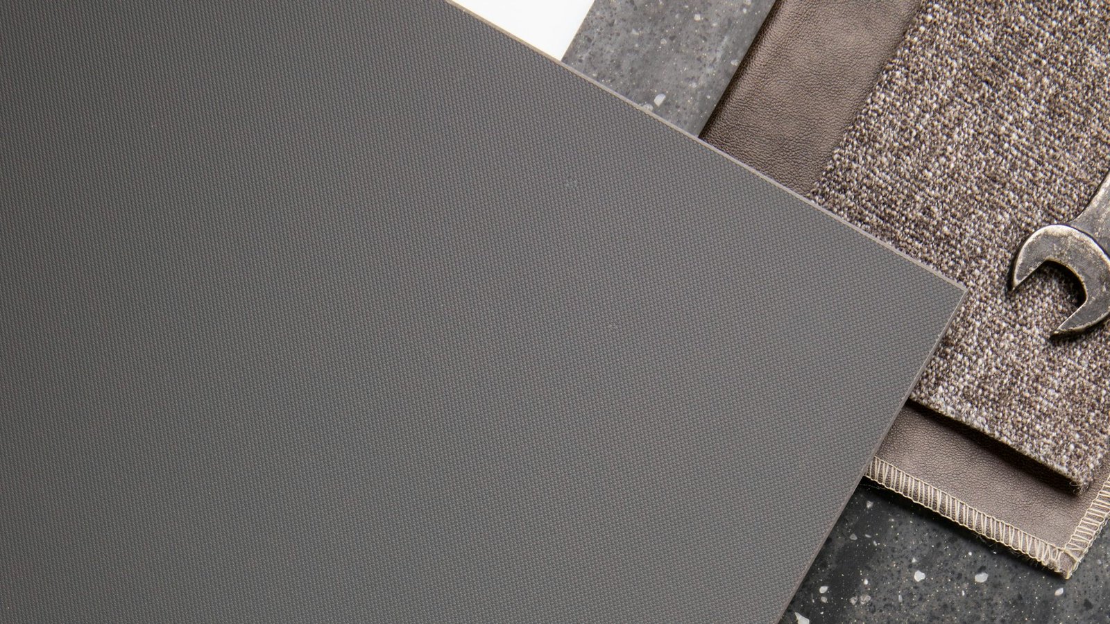 Material samples in muted greys and browns overlapping on a sample board