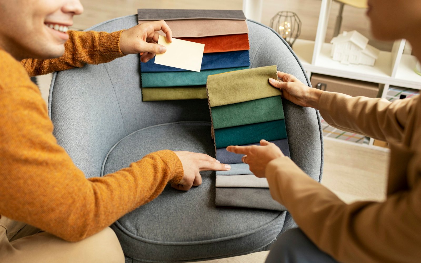 Two people looking through fabric swatches together, one holding out a set of samples